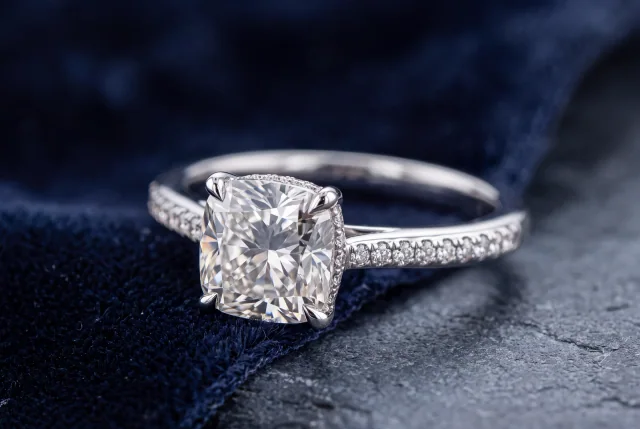 Custom cushion cut engagement ring on navy velvet